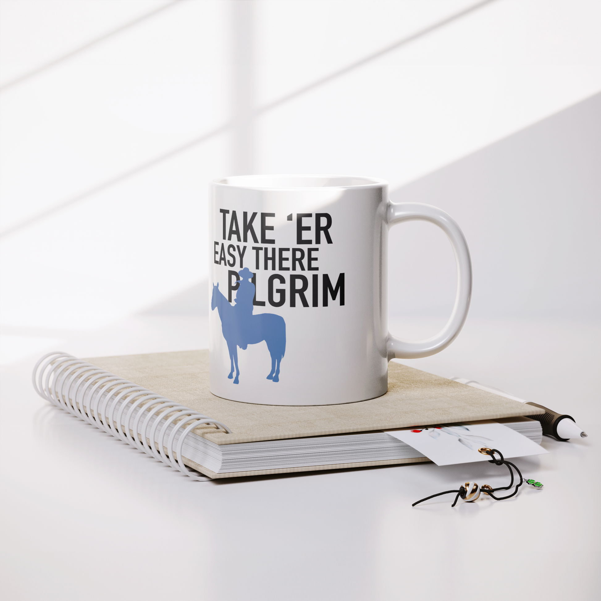 John_Wayne_Inspired_Mug_TAKE_ER_EASY_T_Lifestyle_Notebook_Mockup.png_15541915